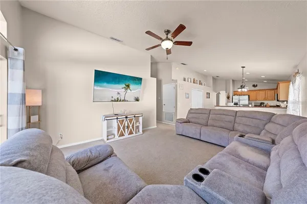 a living room with furniture and kitchen view