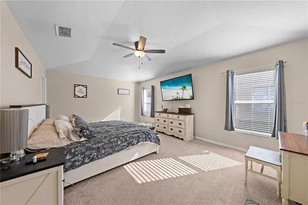 a bedroom with a bed window and a flat screen tv