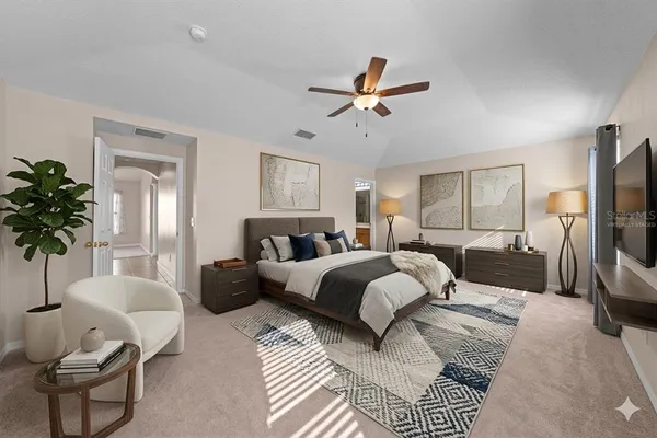 a spacious bedroom with a bed a couch and a potted plant