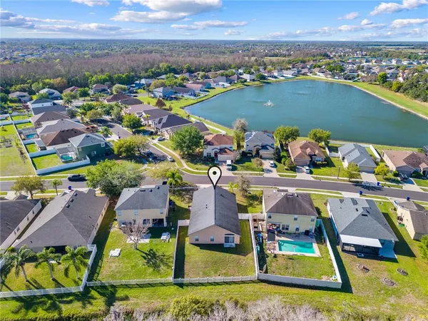 a view of a house with wooden fence and a yard