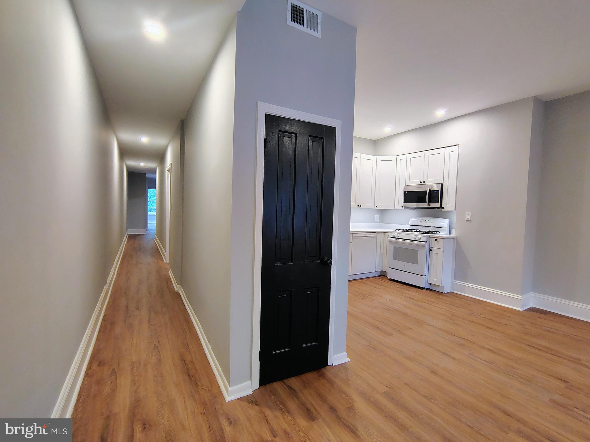 230 South Market Street, Unit 2 Frederick, MD 21701 - Photo 11 of 16 a view of a kitchen with wooden floor electronic appliances and stairs