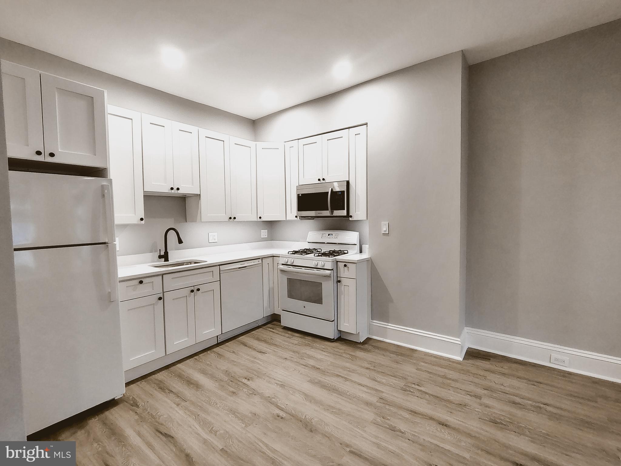 230 South Market Street, Unit 2 Frederick, MD 21701 - Photo 5 of 16 a kitchen with granite countertop white cabinets and stainless steel appliances