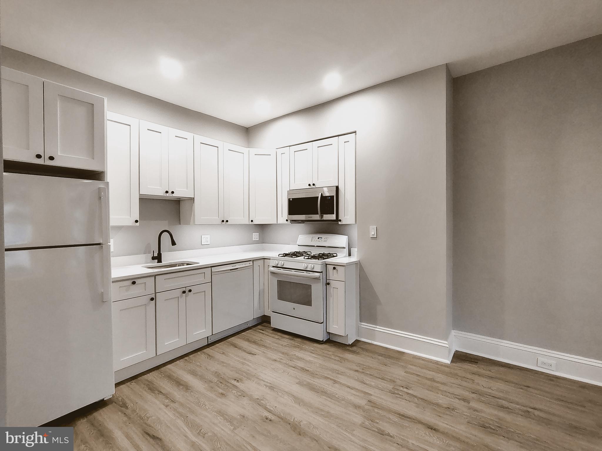230 South Market Street, Unit 2 Frederick, MD 21701 - Photo 6 of 16 a kitchen with stainless steel appliances granite countertop a stove top oven a sink and white cabinets