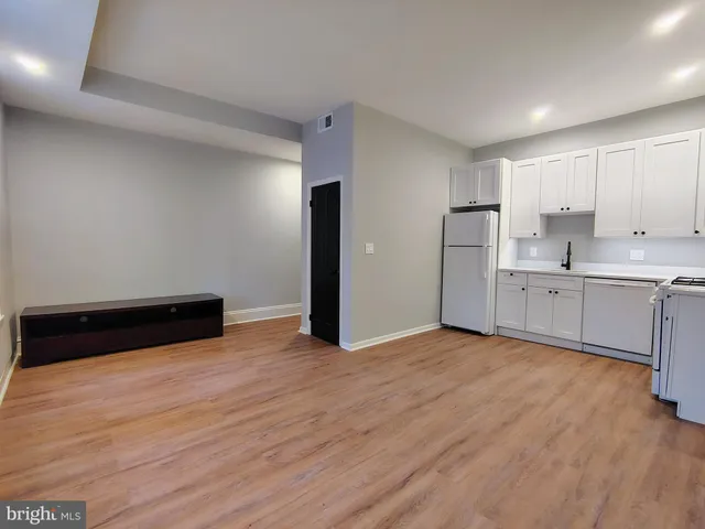 a view of a kitchen with wooden floor and electronic appliances