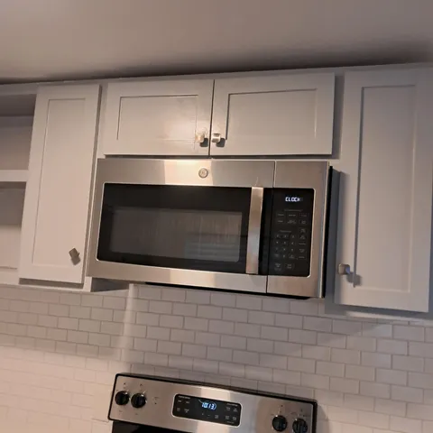 a stove top oven sitting inside of a kitchen