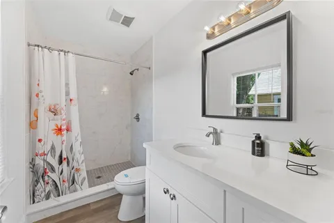 a bathroom with a toilet a sink and a large mirror