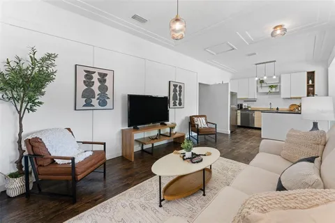 a living room with furniture a rug and a flat screen tv