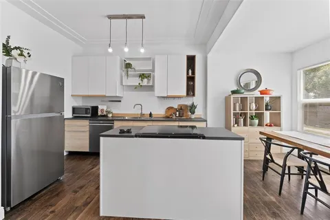 a kitchen with stainless steel appliances granite countertop a refrigerator a stove a sink and a microwave