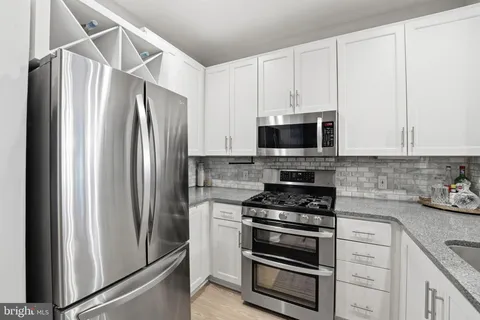 a kitchen with refrigerator a microwave a stove and cabinets