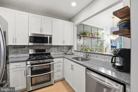 a kitchen with stainless steel appliances a stove a sink and a microwave