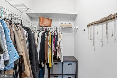 a view of walk in closet with clothes