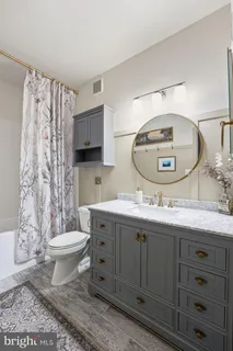 a bathroom with a granite countertop toilet sink and mirror