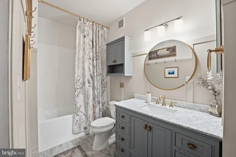 a bathroom with a granite countertop sink a toilet and a mirror