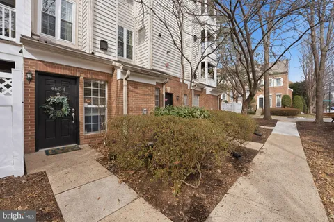 front view of a brick house with a large tree