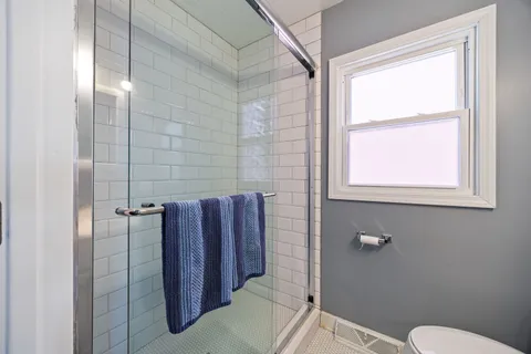 a bathroom with a toilet and a shower