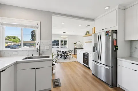 a kitchen with refrigerator a sink and white cabinets