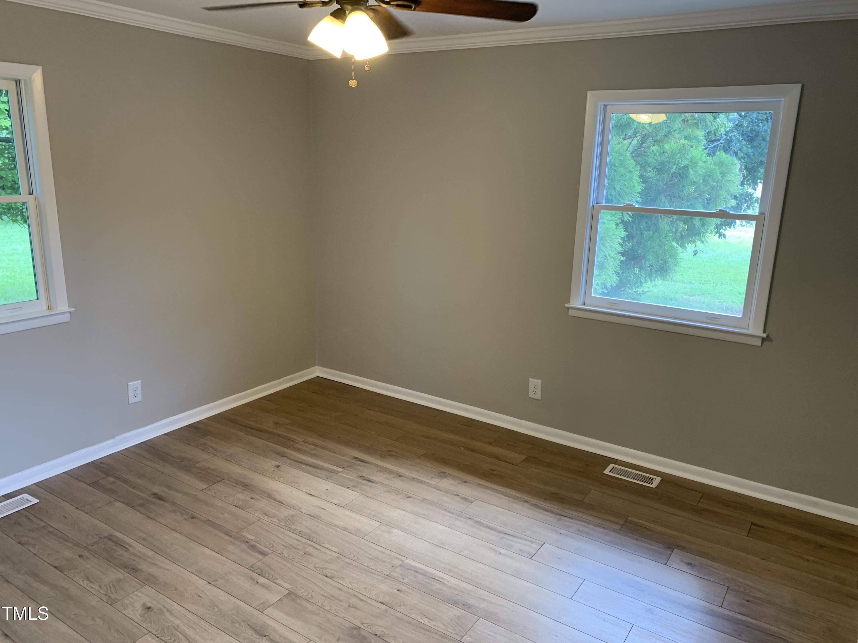 182 Old Lystra Road Chapel Hill, NC 27517 - Photo 14 of 17 an empty room with wooden floor and windows