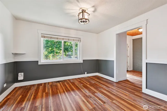 a view of empty room with wooden floor and windows