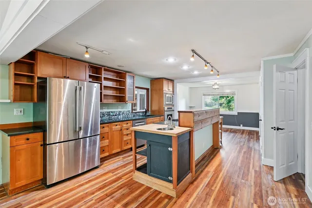 a kitchen with stainless steel appliances a refrigerator sink and stove