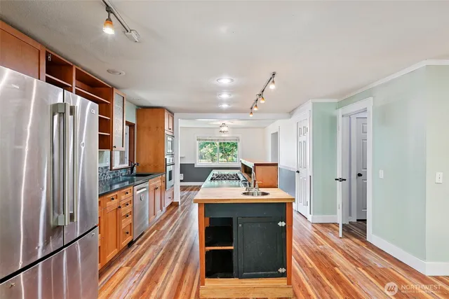 a kitchen with stainless steel appliances granite countertop a sink and a refrigerator