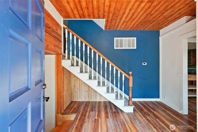 a view of staircase with wooden floor and white walls
