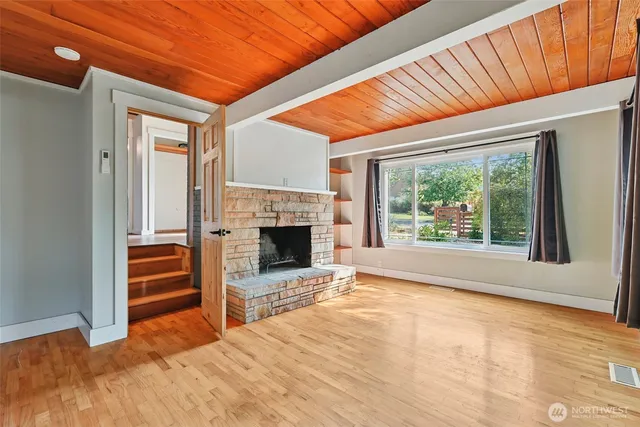 a view of empty room with a fireplace and windows