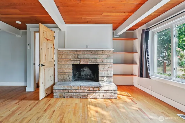 a living room with a fireplace windows and a table