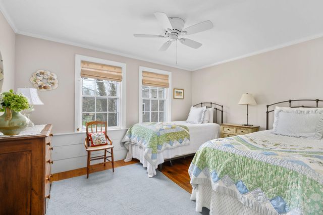 a spacious bedroom with a bed a dresser and a book shelf
