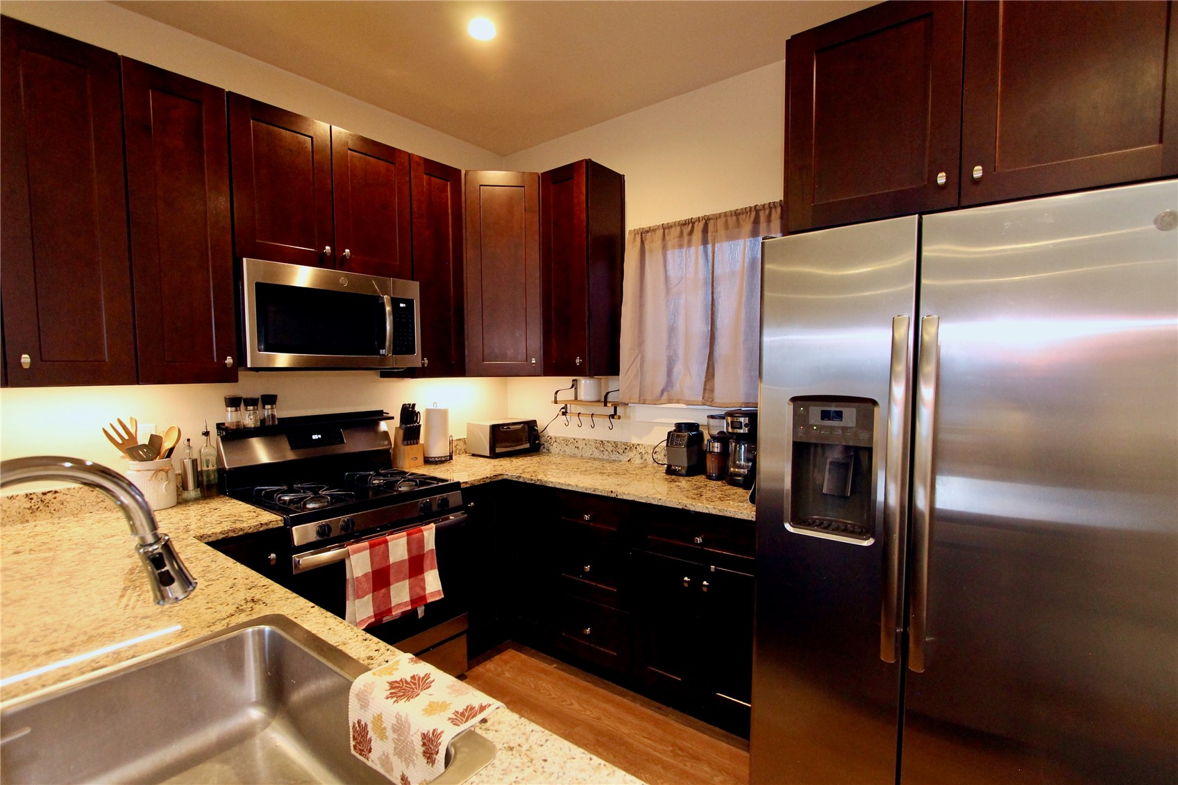 54 Haymaker Street, Unit 54 Silverthorne, CO 80498 - Photo 7 of 21 a kitchen with stainless steel appliances wooden cabinets a sink and a refrigerator