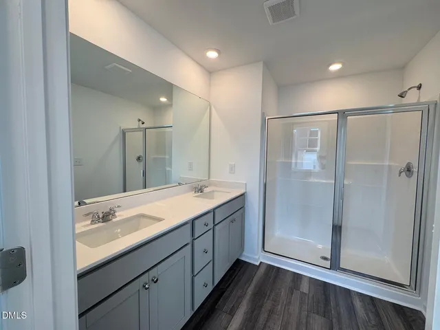 a bathroom with a granite countertop sink mirror and shower