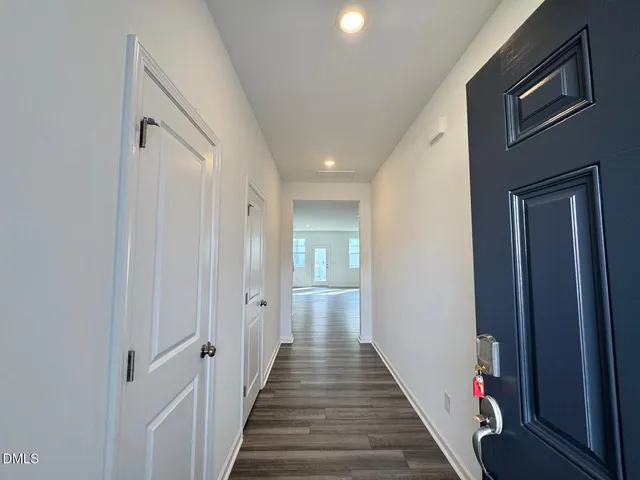a view of a hallway with wooden floor and staircase