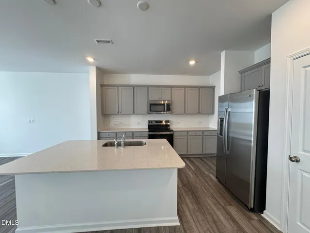 a kitchen with stainless steel appliances a refrigerator sink a stove a microwave and cabinets