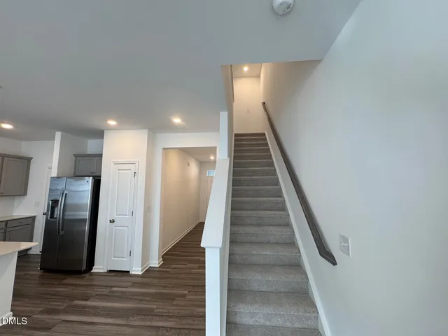 a view of a hallway with stainless steel appliances