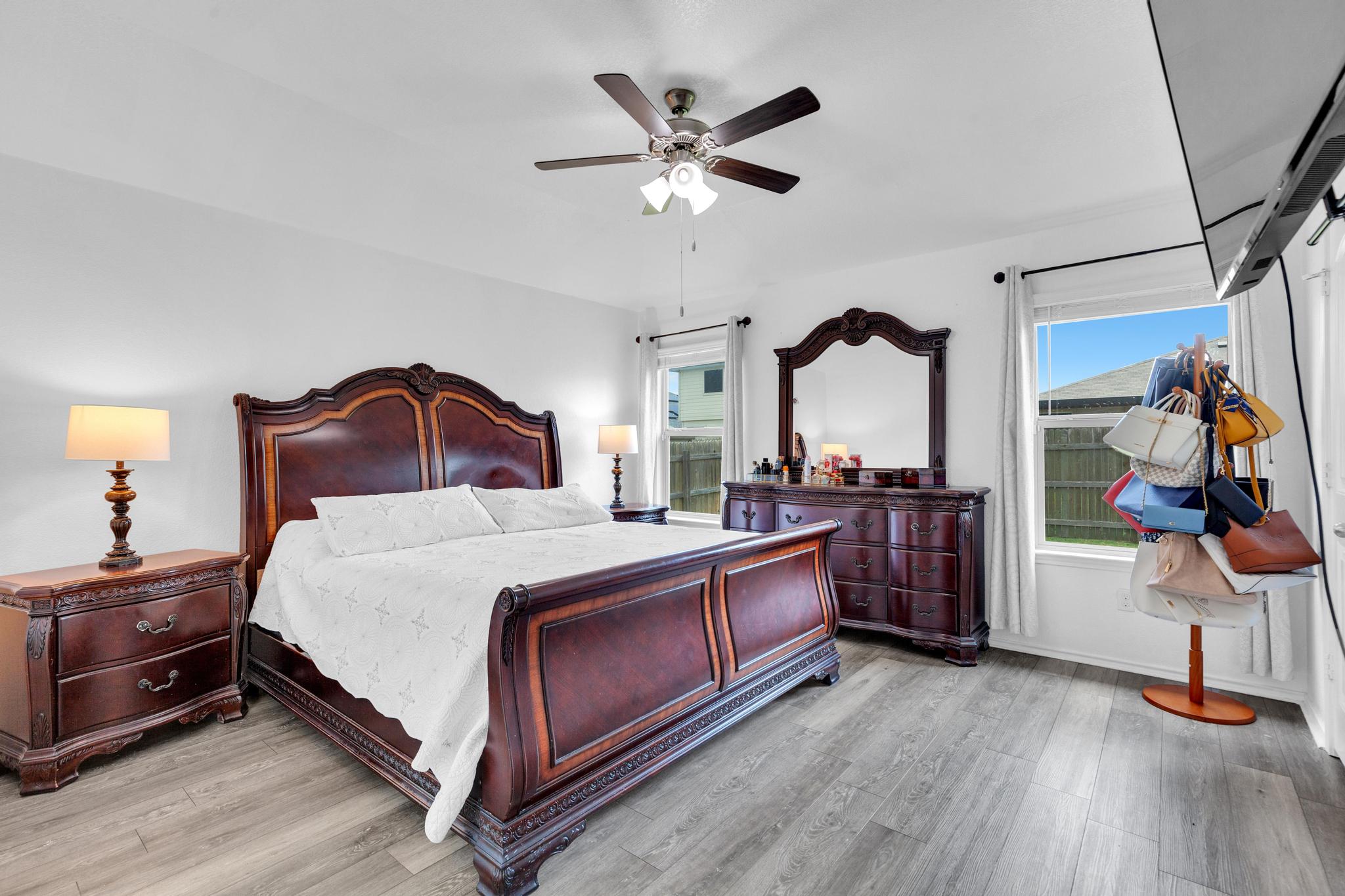 119 Beth Ann Loop Taylor, TX 76574 - Photo 21 of 31 Elegant primary bedroom featuring wood flooring and a classic ceiling fan, providing comfort and style.