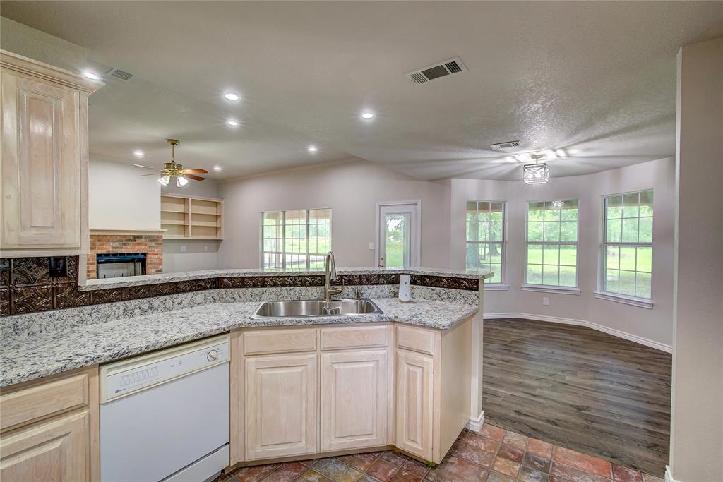 225 Rs County Road 1278 Emory, TX 75440 - Photo 17 of 36 a kitchen with center island wooden floor cabinets and a window