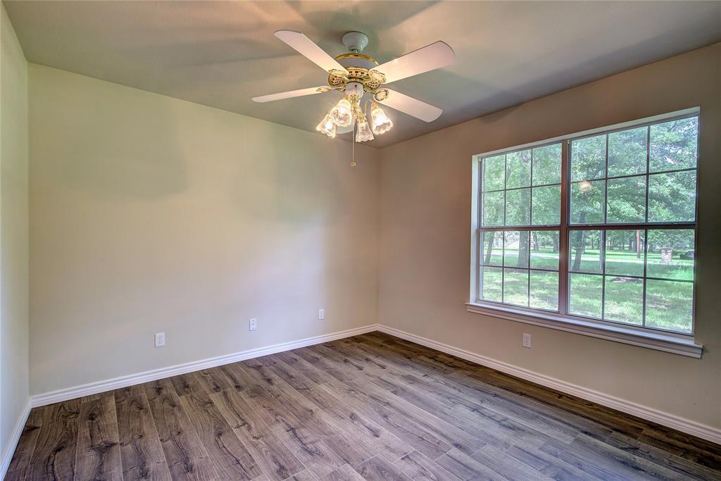 225 Rs County Road 1278 Emory, TX 75440 - Photo 23 of 36 an empty room with wooden floor fan and windows