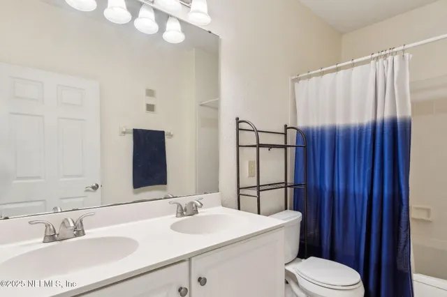a view of a brick house with a big yard and large trees