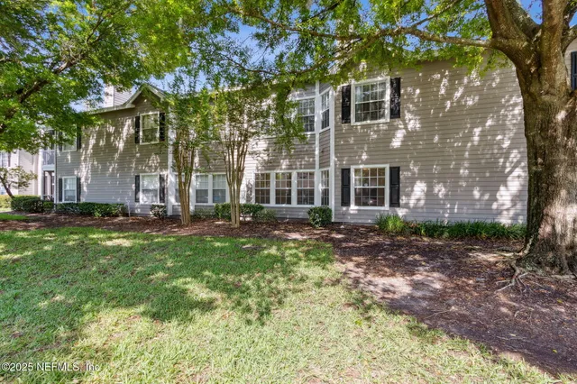 an aerial view of residential houses with outdoor space and trees