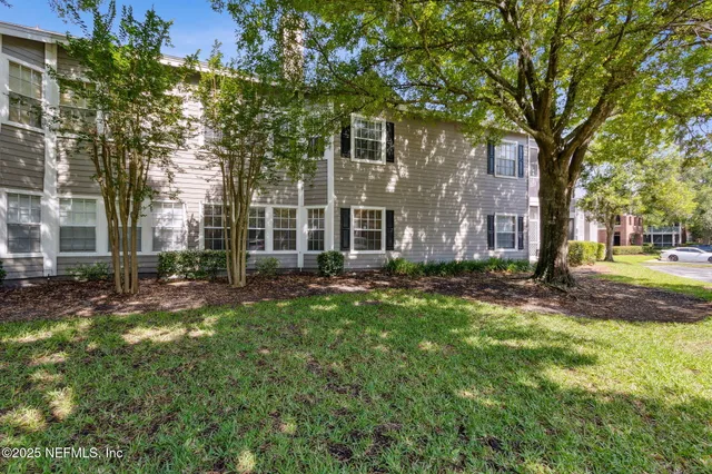 an aerial view of residential houses with outdoor space and trees