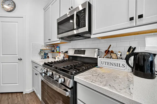 a kitchen with stainless steel appliances granite countertop a stove and a microwave