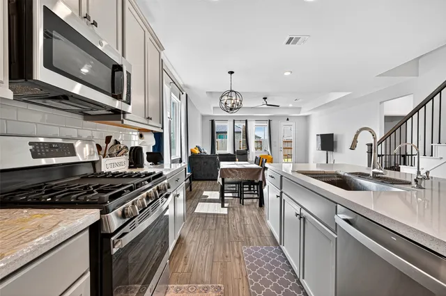 a kitchen with stainless steel appliances granite countertop a stove and a sink