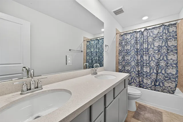a bathroom with a sink a toilet and shower curtain