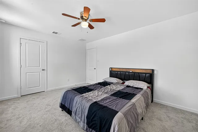 a bedroom with a bed and a ceiling fan
