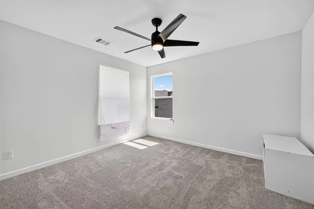a view of empty room with ceiling fan