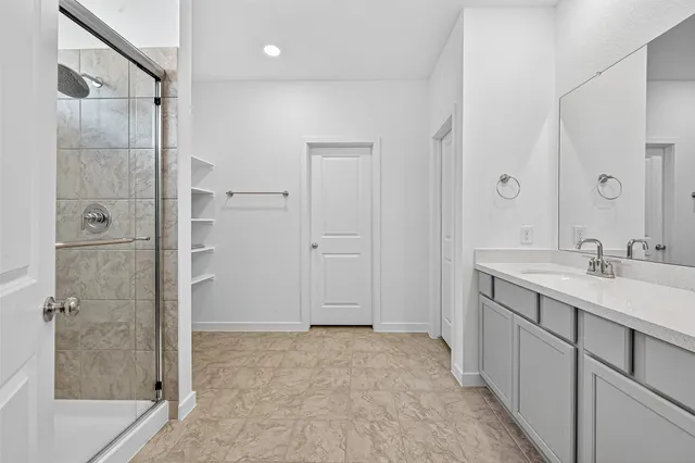 a bathroom with a shower sink and mirror