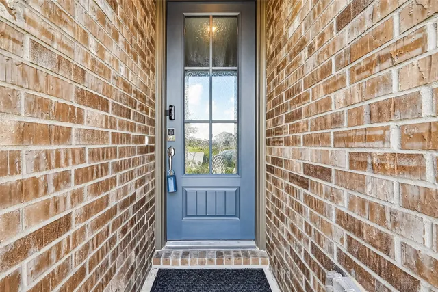 a view of an empty room with wooden floor and a shower