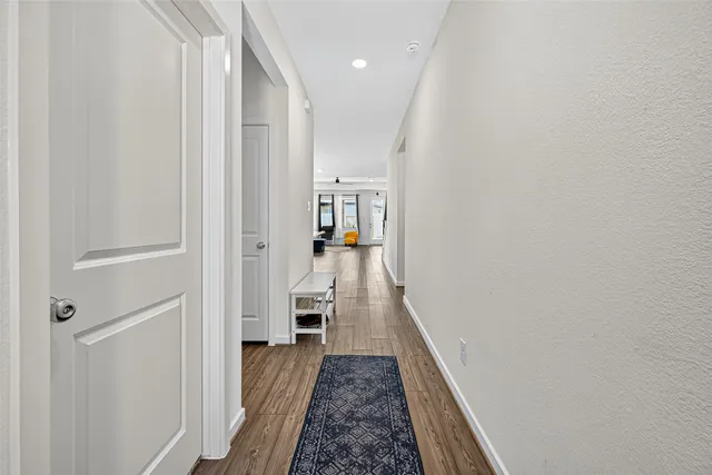 a view of a hallway with wooden floor and furniture