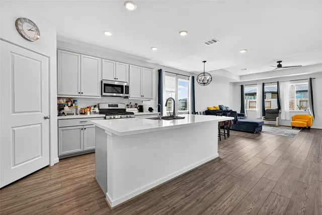 a kitchen with sink a microwave and cabinets