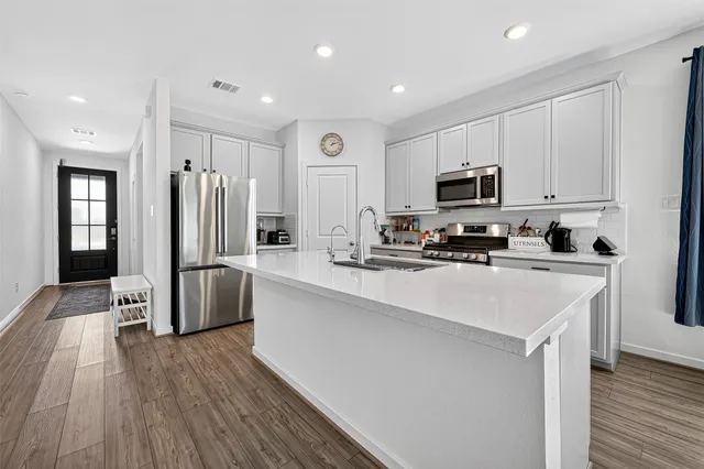 a kitchen with stainless steel appliances a refrigerator stove microwave and cabinets