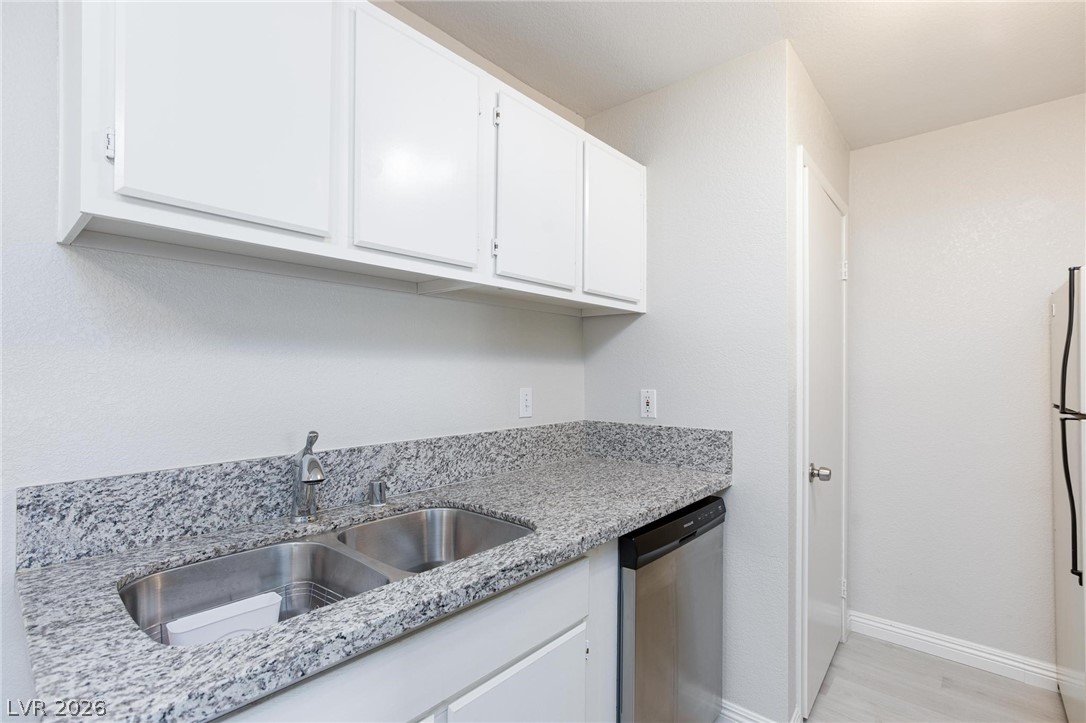 5171 South Lindell Road, Unit 103 Las Vegas, NV 89118 - Photo 10 of 24 Modern kitchen equipped with ample storage, sleek granite counters, and stainless steel appliances.